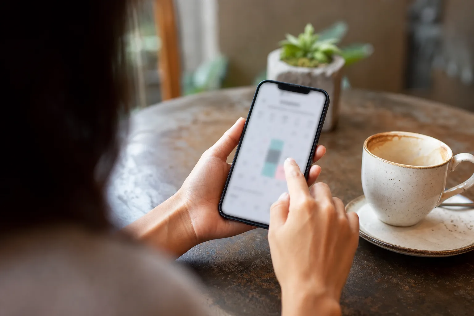 Client booking from a phone over morning coffee — payment happens in the same flow as the appointment